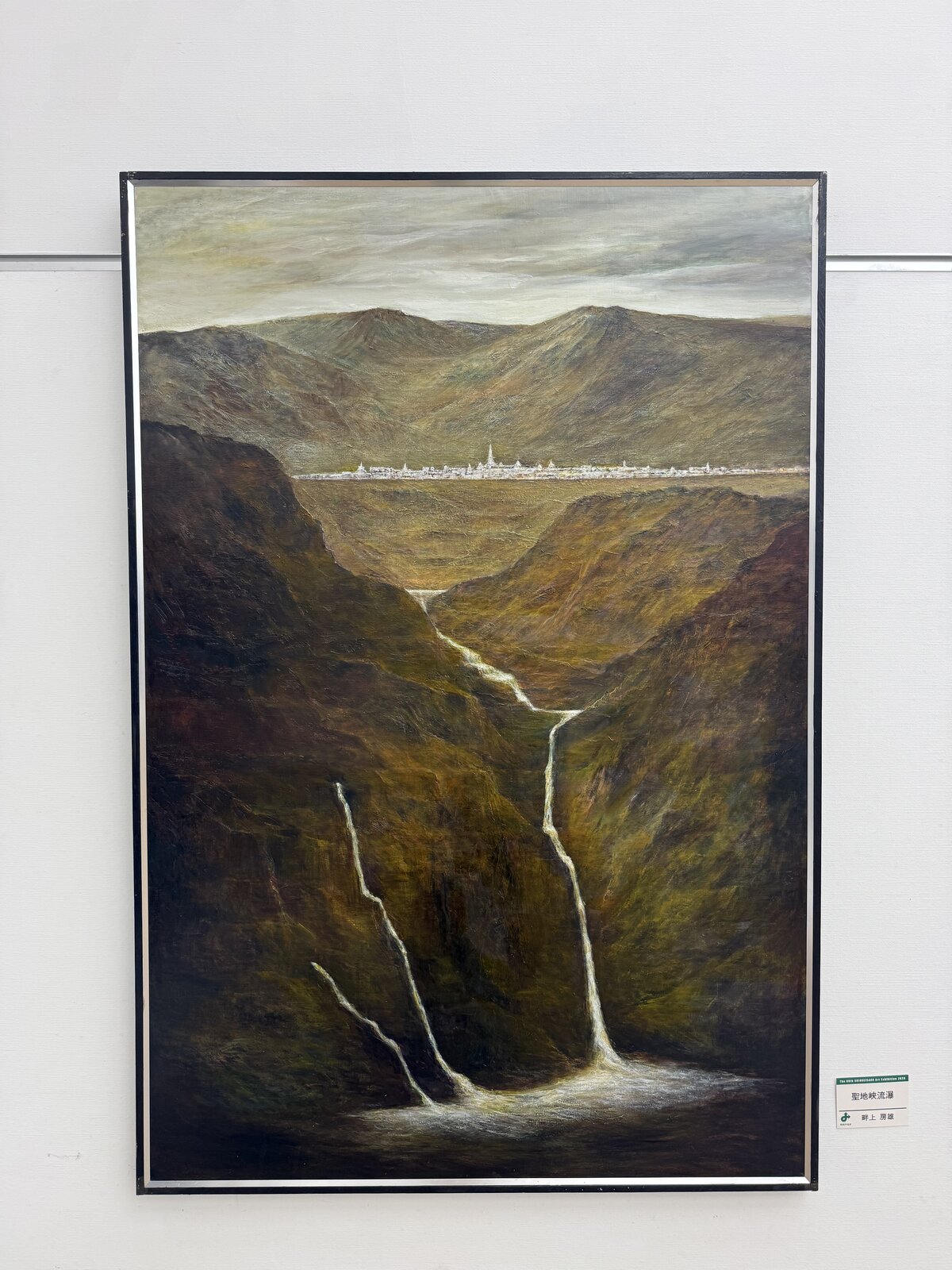 Sacred Gorge Cascade by Azegami Fusao: waterfalls in a gorge below a distant town